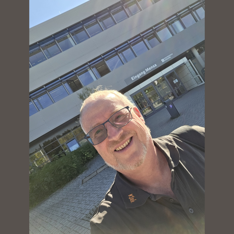 Jochen Kleh macht ein Selfie vor dem Eingang Mensa der Hochschule Koblenz