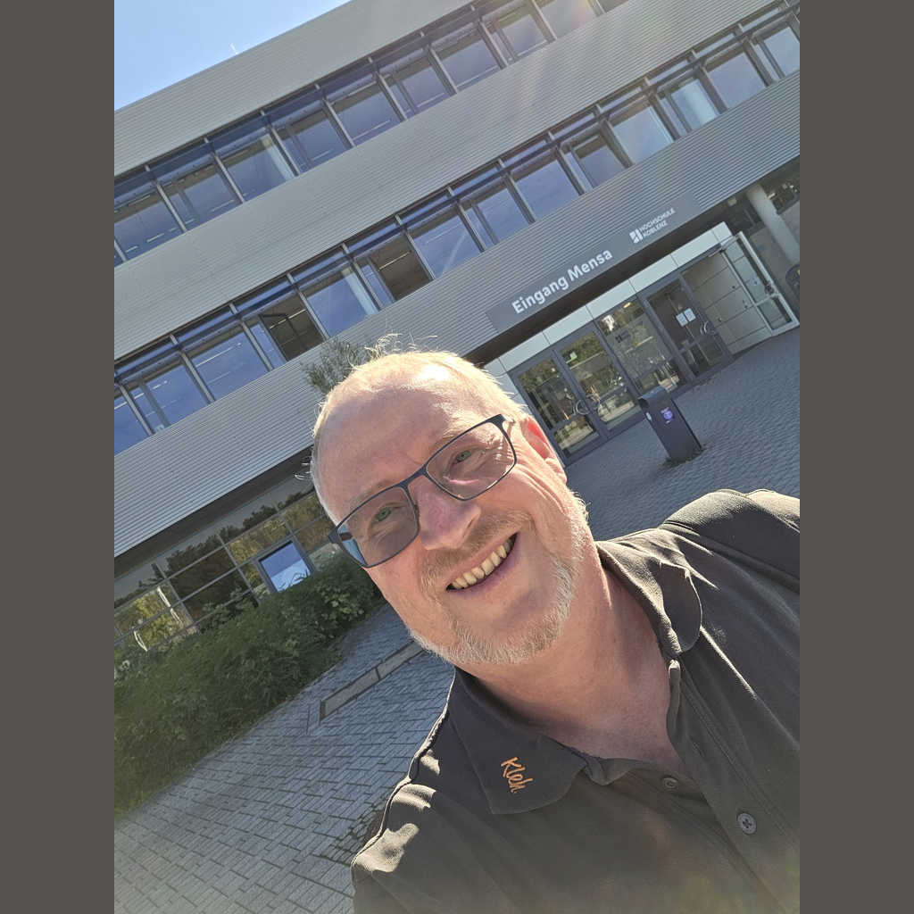 Jochen Kleh macht ein Selfie vor dem Eingang Mensa der Hochschule Koblenz